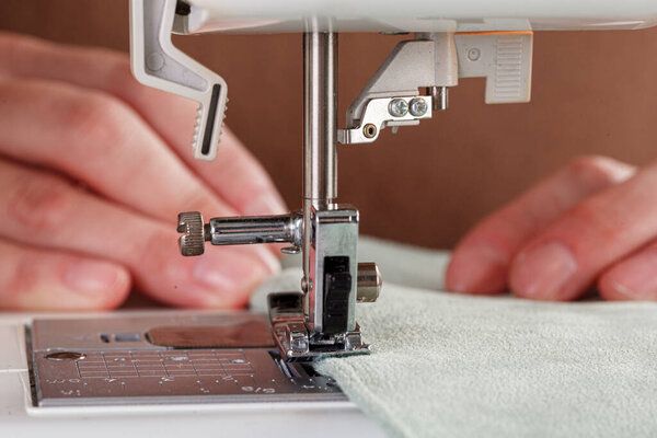 Швейная машина, сшивальная ткань, игла в круговом плане крупным планом