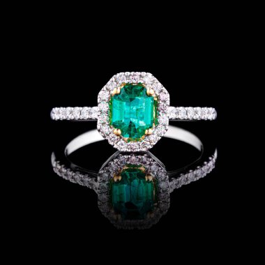 Elmas ve zümrüt kaplamalı güzel beyaz altın bir yüzük.