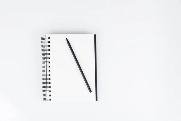 business notepad with pencil on white background close-up