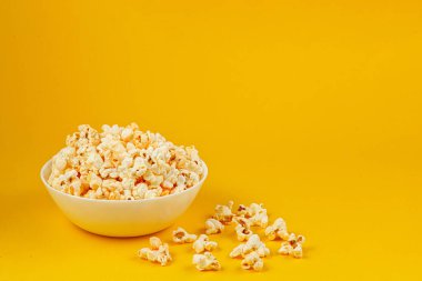 Sarı arka planda patlamış mısır tabağı.