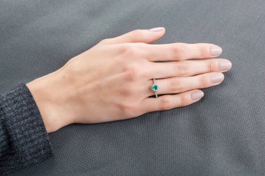Altın yüzüklü, elmaslı ve zümrüt kaplamalı güzel bir kadın eli.