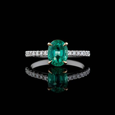 Elmas ve zümrüt kaplamalı güzel beyaz altın bir yüzük.