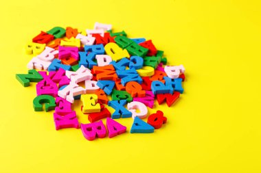 Alfabenin sarı arkaplan yakın plan üzerindeki renkli harfleri