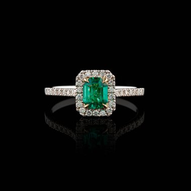 Elmas ve zümrüt kaplamalı güzel beyaz altın bir yüzük.