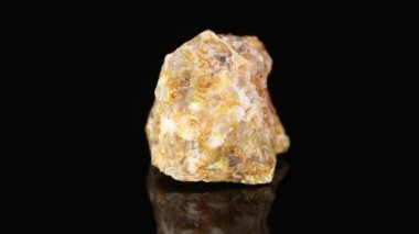 Parlatılmış mineral taşı Opal siyah arka planda yakın plan daire şeklinde döner