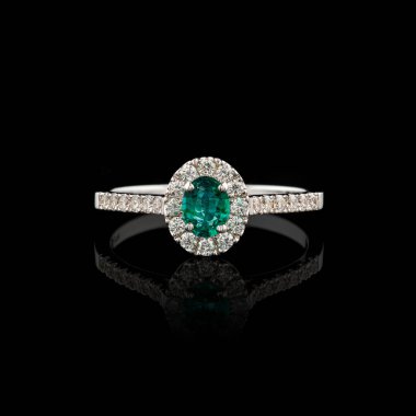 Elmas ve zümrüt kaplamalı güzel beyaz altın bir yüzük.