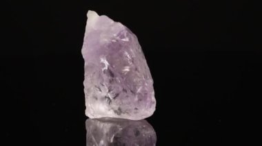 Parlatılmış mineral taşı Ametist siyah arka planda yakın plan daire şeklinde döner