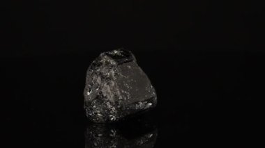 Cilalanmış mineral taşı Schorl siyah bir arkaplan üzerinde bir daire içinde döner