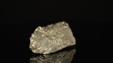 Parlatılmış mineral taş pirit siyah arka planda bir daire şeklinde döner.