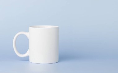 white cup for tea or coffee on a blue background close-up