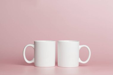 white cups for tea or coffee on a pink background close-up