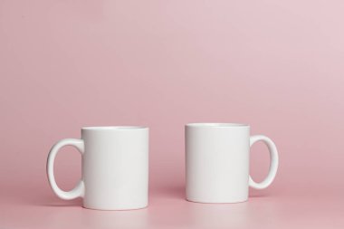 white cups for tea or coffee on a pink background close-up