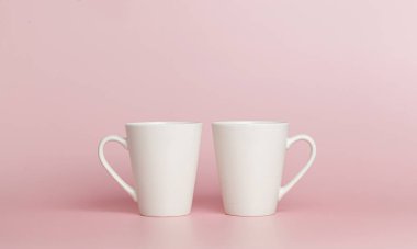 white cups for tea or coffee on a pink background close-up