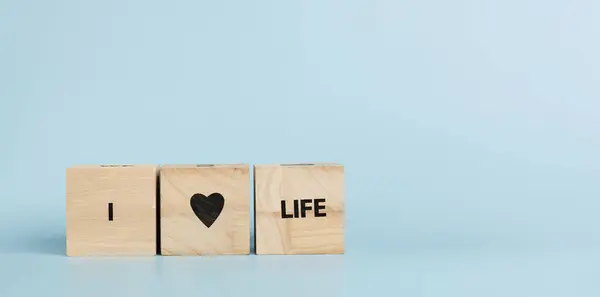 stock image Wooden cubes with inscriptions I Love Life on a blue background close-up