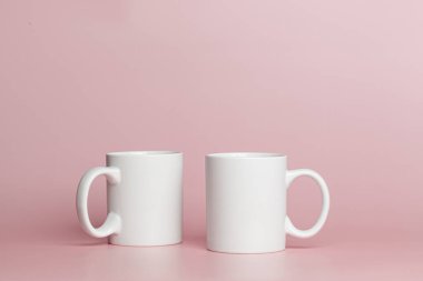 white cups for tea or coffee on a pink background close-up