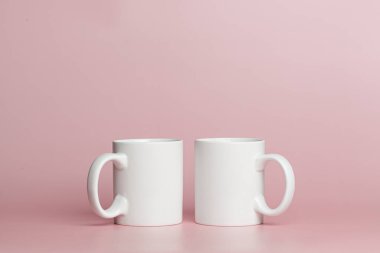 white cups for tea or coffee on a pink background close-up