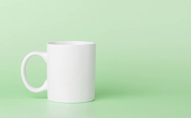 Yeşil arka planda çay ya da kahve içmek için beyaz bardak.