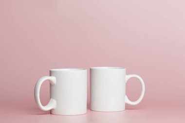 white cups for tea or coffee on a pink background close-up