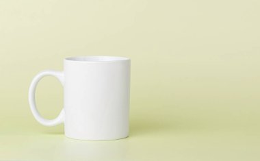 Çay için beyaz kupa ya da yakın plan sarı bir fonda kahve.