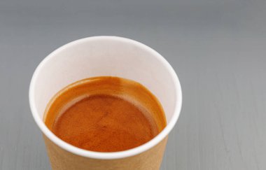 Kahve, espresso, americano ve gri ahşap arka planda karton bardaklar.