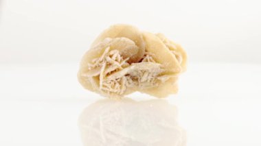 Çöl gülleri mineral taşı yakın plan beyaz bir zeminde daireler çiziyor.