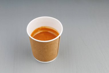 Kahve, espresso, americano ve gri ahşap arka planda karton bardaklar.