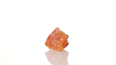 Mineral taşı carnelian beyaz arka planda bir daire içinde döner.