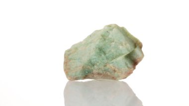 Amazonite mineral taşı yakın plan beyaz bir zeminde daireler çiziyor.