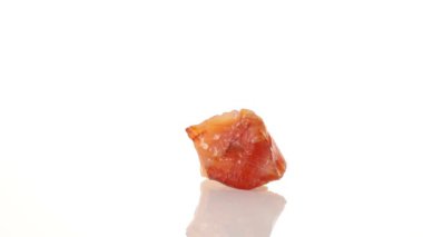 Mineral taşı carnelian beyaz arka planda bir daire içinde döner.