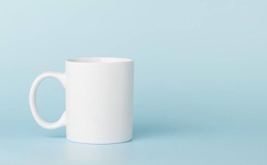 white cup for tea or coffee on a blue background close-up