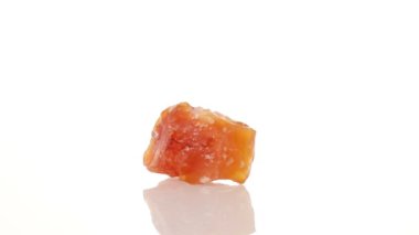 Mineral taşı carnelian beyaz arka planda bir daire içinde döner.