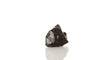 Mineral taşı Schorl beyaz arkaplanda yakın plan daire şeklinde döner