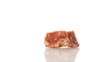 Halit mineral taşı yakın plan beyaz bir zeminde daireler çiziyor.