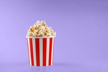 Klasik kırmızı çizgili patlamış mısır karton bardak Mor, menekşe arka plan yakın plan