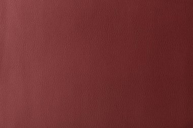 Texture of genuine leather, artificial leatherette red background close-up