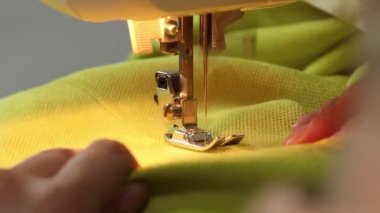 Dikiş makinesinin kumaş dikme işlemi, dikiş makinesi iğnesi yakın çekim hareketi.