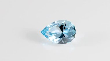Aquamarine mavi yüzlü armut kesim taş mineral makro video beyaz izole arka plan yakın çekim bir daire içinde dönüyor