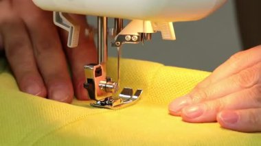 Dikiş makinesinin kumaş dikme işlemi, dikiş makinesi iğnesi yakın çekim hareketi.