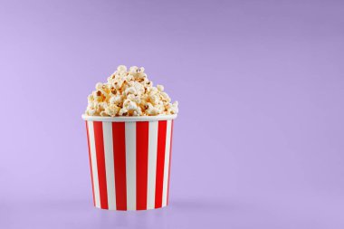 Klasik kırmızı çizgili patlamış mısır karton bardak Mor, menekşe arka plan yakın plan