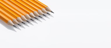 Beyaz arka planda sivri uçlu yakın plan sarı grafit kalemler. Ofis kullanımı ve sanat malzemeleri için harika.