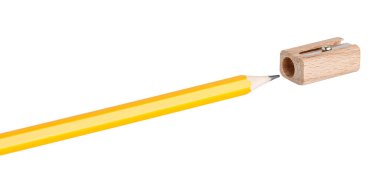 Tahta keskinleştirici makro çekimde beyaz zemin üzerinde sarı bir kalem keskinleştiriyor. Dünya çapında eğitim ve kırtasiye için ideal.