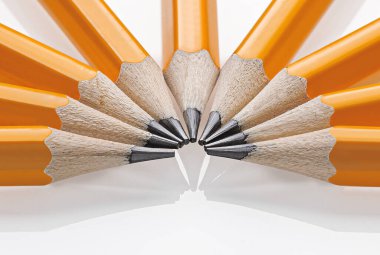 Keskinleştirilmiş sarı grafit kalemler beyaz arka planda bir vantilatöre yerleştirilmiş. Okul gereçleri ve yaratıcı projeler için mükemmel.