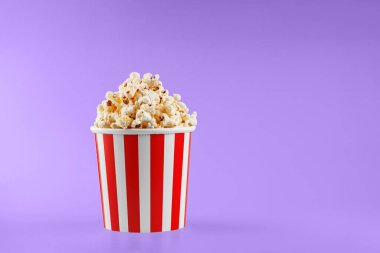 Klasik kırmızı çizgili patlamış mısır karton bardak Mor, menekşe arka plan yakın plan