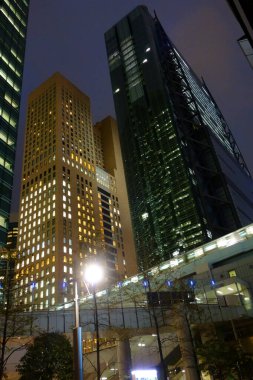 Tokyo, Japonya - 17 Ekim 2018: Futuristik Shinbashi Shiodome Binası, yanıp sönen asansörler, aşağıdan geçen raylar