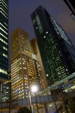 Tokyo, Japonya - 17 Ekim 2018: Futuristik Shinbashi Shiodome Binası, yanıp sönen asansörler, aşağıdan geçen raylar