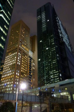 Tokyo, Japonya - 17 Ekim 2018: Futuristik Shinbashi Shiodome Binası, yanıp sönen asansörler, aşağıdan geçen raylar