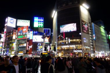 Tokyo, Japonya - 22 Ekim 2018: Gece kentinde insanlar Shibuya İstasyonu 'nun önündeki hendek geçidine doğru koşuşturuyorlar.