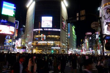 Tokyo, Japonya - 22 Ekim 2018: Gece kentinde insanlar Shibuya İstasyonu 'nun önündeki hendek geçidine doğru koşuşturuyorlar.