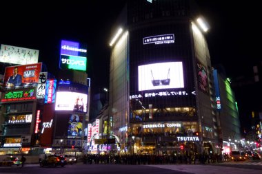 Tokyo, Japonya - 22 Ekim 2018: Gece kentinde insanlar Shibuya İstasyonu 'nun önündeki hendek geçidine doğru koşuşturuyorlar.