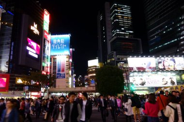 Tokyo, Japonya - 22 Ekim 2018: Gece kentinde insanlar Shibuya İstasyonu 'nun önündeki hendek geçidine doğru koşuşturuyorlar.